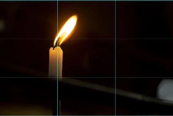 A lit candle on a dark background.