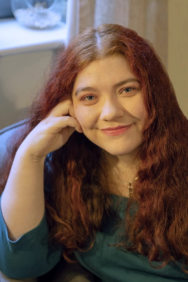 A portrait of a woman looking into the camera, leaning on her hand, during a professional photography packages